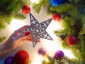 Female ÃÂaucasian hand with red nails holding Christmas star. Christmas decor, hand care concept Royalty Free Stock Photo